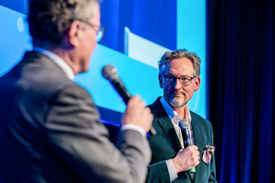 Dr. Eckart von Hirschhausen in conversation with Rainer Gessler on stage.