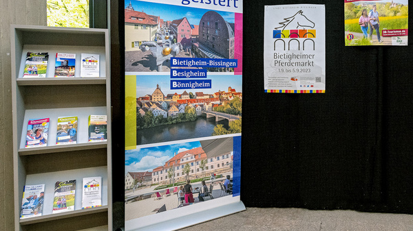 Eine Ausstellung mit Informationsständen über das 3B-Land und Besigheim. Links steht ein Regal mit Broschüren, rechts befinden sich große Aufsteller mit Bildern und Texten zu Sehenswürdigkeiten. Im Hintergrund ist ein schwarzes Tuch, das den Raum abgrenzt.