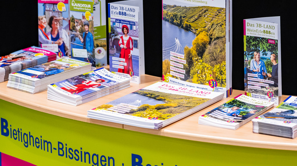 Ein Tisch mit verschiedenen Broschüren und Informationen über die Region "3B-LAND", die die Städte Bietigheim-Bissingen, Besigheim und Bönnigheim vorstellen. Im Vordergrund liegen Reise- und Freizeitführer für 2025, um Besuchern Anregungen zu bieten.