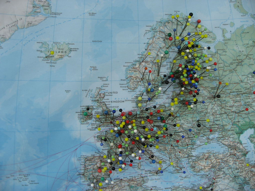 Bild: Tomi Knuutila, Lizenz: CC BY 2.0 Eine Landkarte von Europa, auf der viele bunte Stecknadeln in verschiedenen Farben angebracht sind. Die Nadeln markieren verschiedene Standorte, während rote Linien einige dieser Orte miteinander verbinden. Die Karte zeigt ein Netzwerk von Verbindungen in der Region.