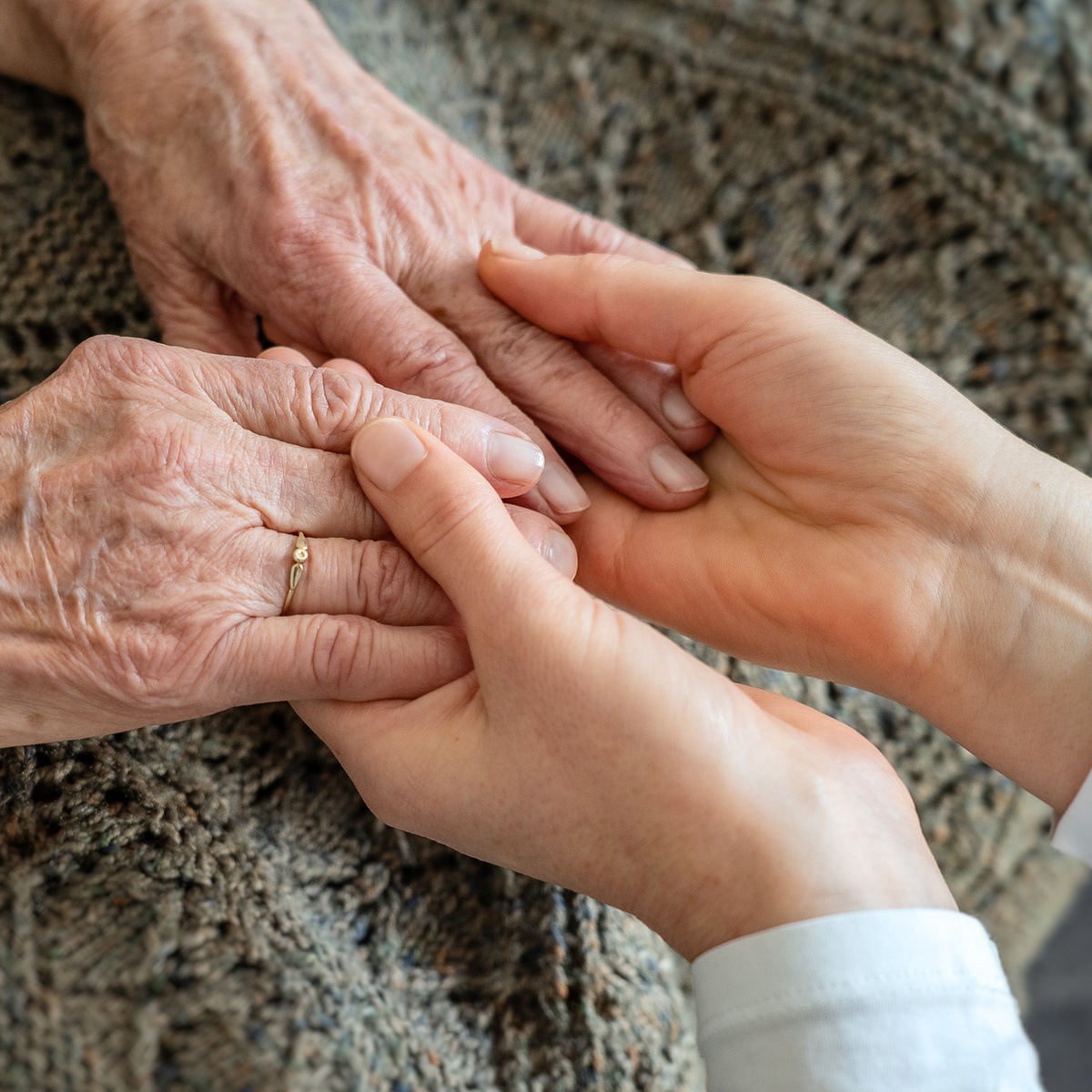 Junge Hände halten alte Hände