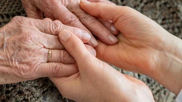 Junge Hände halten alte Hände