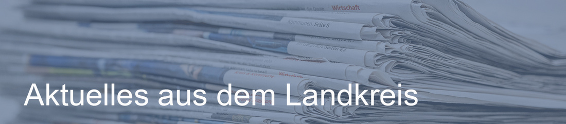 Ein Stapel Zeitungen liegt übereinander. Darüber steht der Text "Aktuelles aus dem Landkreis". (Text KI generiert)