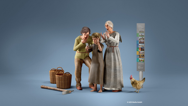 Drei Figuren, ein Mann, ein Kind und eine ältere Frau, stehen zusammen und schauen gespannt auf ein mobiles Gerät. Neben ihnen stehen zwei Körbe und ein Huhn befindet sich am Boden. Im Hintergrund ist ein Informationsschild sichtbar.