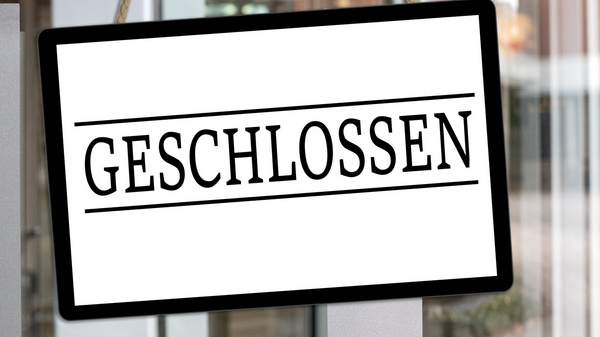 Ein Schild hängt an der Tür und zeigt das Wort "GESCHLOSSEN" in großen Buchstaben. Das Schild weist darauf hin, dass der Zutritt zum Geschäft nicht möglich ist.