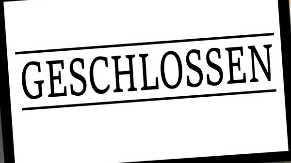 Ein Schild hängt an der Tür und zeigt das Wort "GESCHLOSSEN" in großen Buchstaben. Das Schild weist darauf hin, dass der Zutritt zum Geschäft nicht möglich ist.