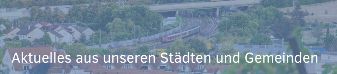 Eine weitläufige Stadtansicht mit grünen Bäumen und Wohngebäuden, während ein Zug in der Nähe vorbeifährt. Oben steht der Text „Aktuelles aus unseren Städten und Gemeinden“.