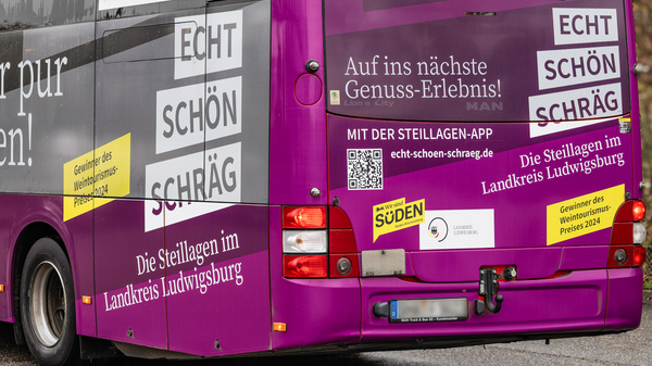 Ein lila Stadtbus zeigt die Aufschrift "Kultur pur erleben" sowie Werbung für die App mit dem Titel "STELLAGEN-APP". Der Bus weist auf Genuss-Erlebnisse im Landkreis Ludwigsburg hin und lädt zur Nutzung der App ein.