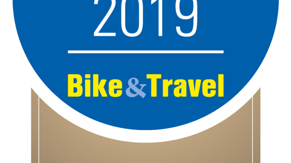 A badge displaying "Top Flussradtouren 2019" with "Bike & Travel" in yellow below. It indicates third place for the "Neckartal-Radweg" cycling route. The design features a blue circular background with a beige ribbon at the bottom.