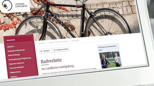 Ein Laptop zeigt eine Webseite des Landkreises Ludwigburg zum Thema Radverkehr. Im Hintergrund ist ein Fahrrad zu sehen, das an einer Mauer lehnt. Die Webseite beinhaltet Links zu verschiedenen Informationen und Dienstleistungen.