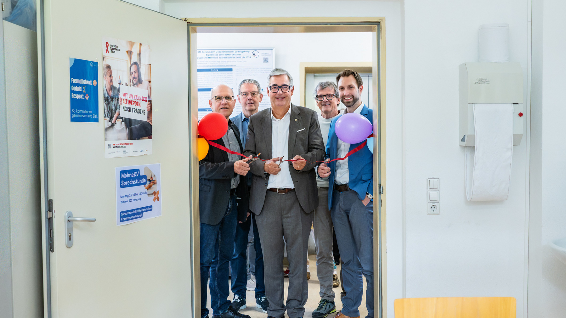 Martin Strecker (Geschäftsführer Kreisdiakonieverband), Heinrich Knodel (Projektleitung Kreisdiakonieverband), Landrat Dietmar Allgaier, Dr. med. Jürgen Maier (Ehrenamtlicher), Marc Dressel (Leiter Caritas Ludwigsburg-Waiblingen-Enz) eröffnen offiziell die Sprechstunde für Menschen ohne Krankenversicherung und schneiden rotes Band durch