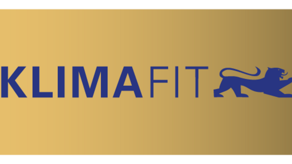 Logo de Klimafit sur fond dégradé doré et bleu. Le mot "KLIMAFIT" est en lettres majuscules sur la gauche, suivi d'une illustration d'un lion. À droite, le texte "UNTERNEHMEN MACHEN KLIMASCHUTZ" est visible, soulignant l'engagement des entreprises pour la protection climatique.