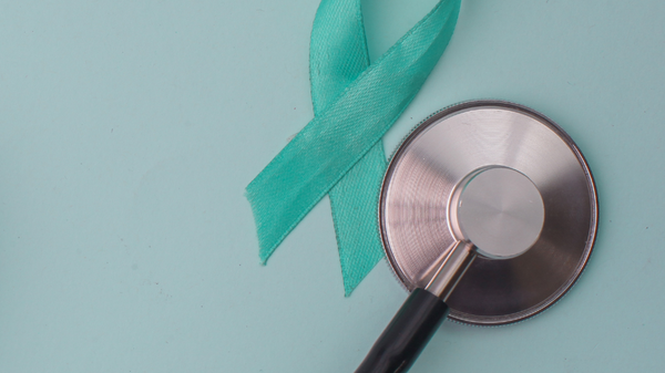 Ein Stethoskop liegt auf einem sanft blauen Hintergrund, daneben befindet sich ein helltürkisfarbendes Awareness-Band. Das Bild symbolisiert Gesundheitsbewusstsein und Unterstützung für bestimmte Krankheiten.