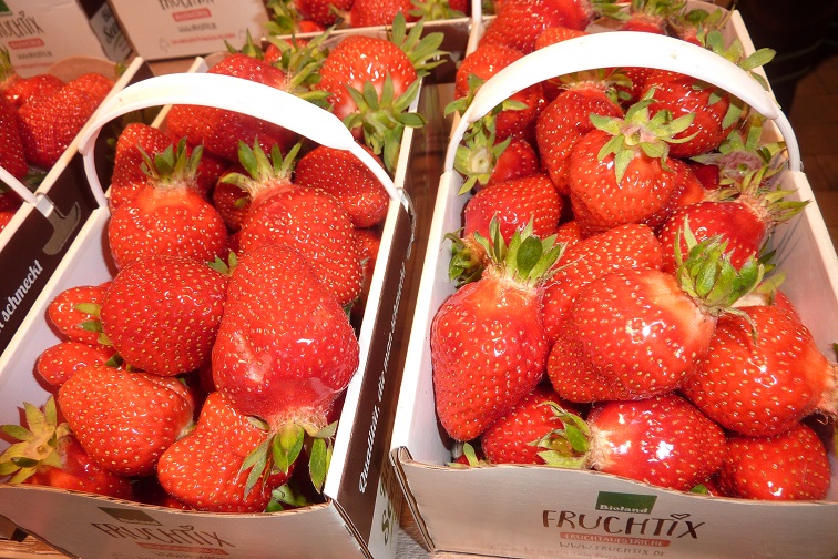 Due ceste di fragole rosse e succose, piene di frutti freschi. Le fragole sono lucide e mature, con foglie verdi ancora attaccate. L'immagine trasmette un senso di freschezza e abbondanza.